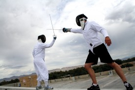 Fencing team members Geoffrey Miller and Brian Kolb duel on the roof of the parking garage.