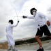 Fencing team members Geoffrey Miller and Brian Kolb duel on the roof of the parking garage.