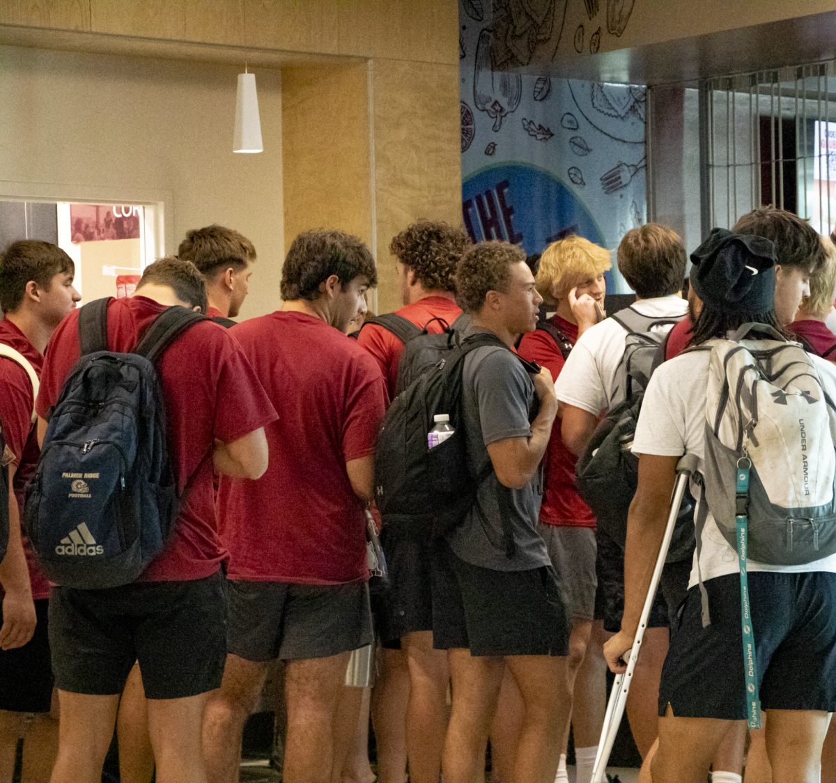 Early Start athletes gather outside of The Caf following football practice.