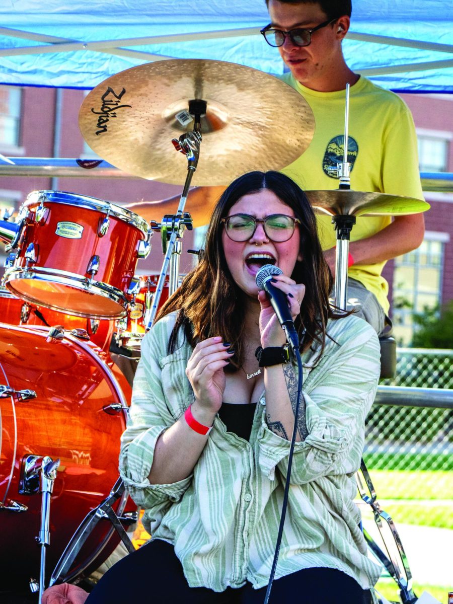 Singing Kid Caravan’s original song “Character Development,” Sydnee Wyrwas-Longoria belts out a high note while Charles Reilly adds complexity on the drums behind her.