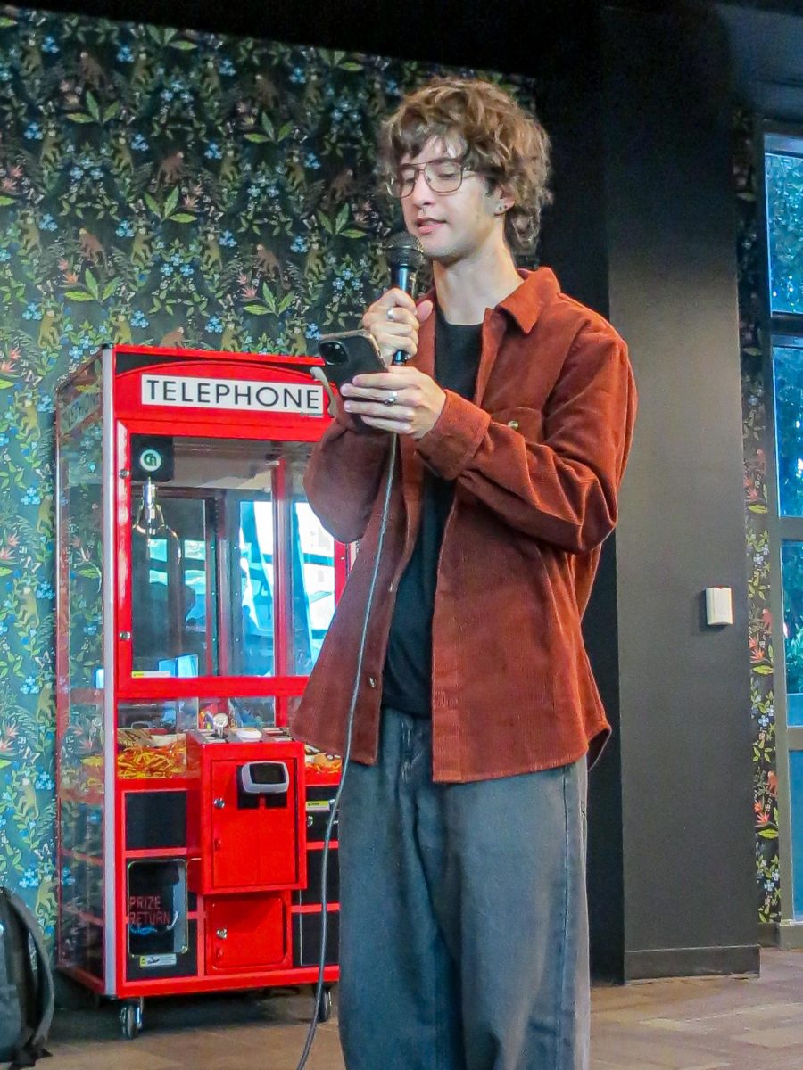 Sophomore biology major Jack Loch reads his story “The Fly” at the Writers’ Guild open mic event. A total of 10 students shared their best pieces.
