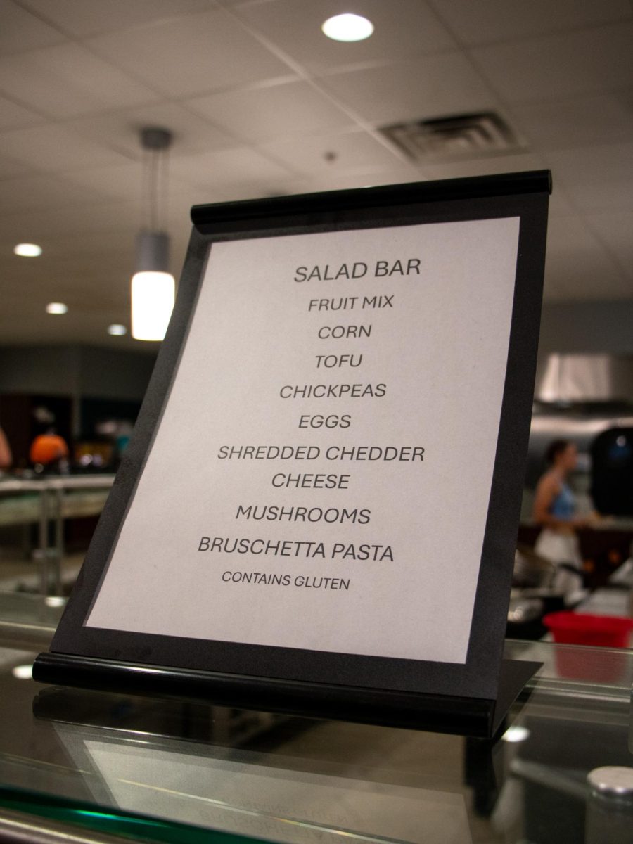 A sign from the on-campus dining hall, The Caf, outlines nine foods present at the salad bar, and indicates that none of these options are gluten-free. The Caf’s lack of an allergy-free food station has sidelined students with life-threatening food allergies, such as Celiac disease, who must still pay for a meal-plan while living on campus.