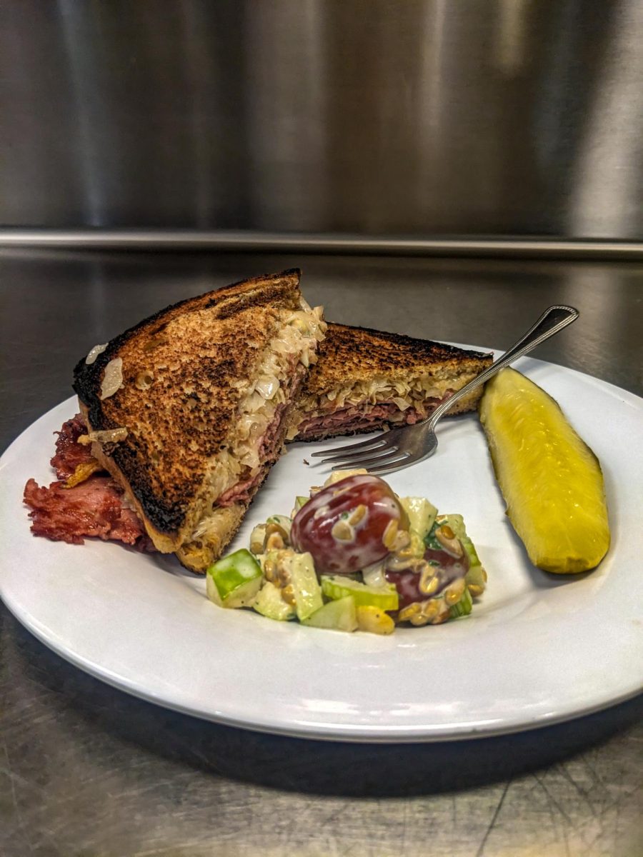 A rueben sandwich prepared by Alex Burrows, a student in the CMU Culinary Arts Program. It's accompanied by a Waldorf salad a pickle spear.