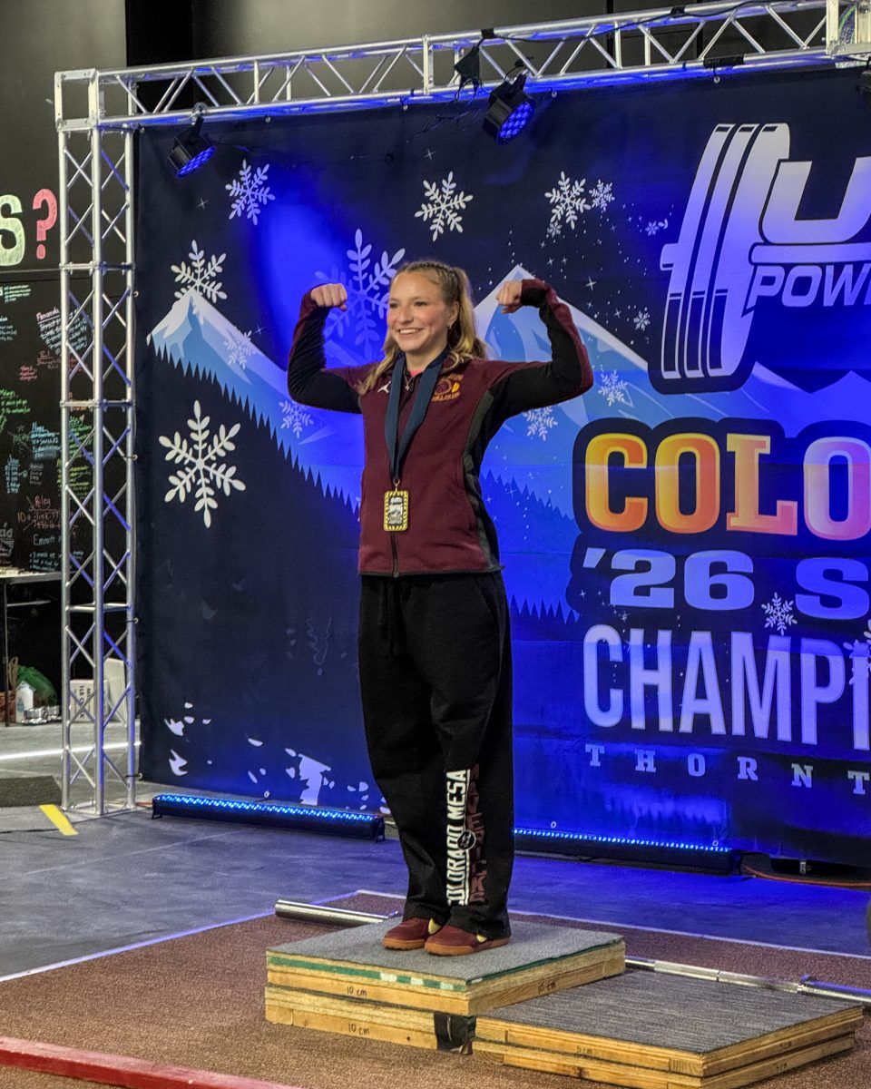 Marissa Martinez-Quezada strikes a pose while standing in the first place spot on the podium. She broke the Colorado State Bench Press Record for the 52kg Teen 3 weight class with 83 lbs.