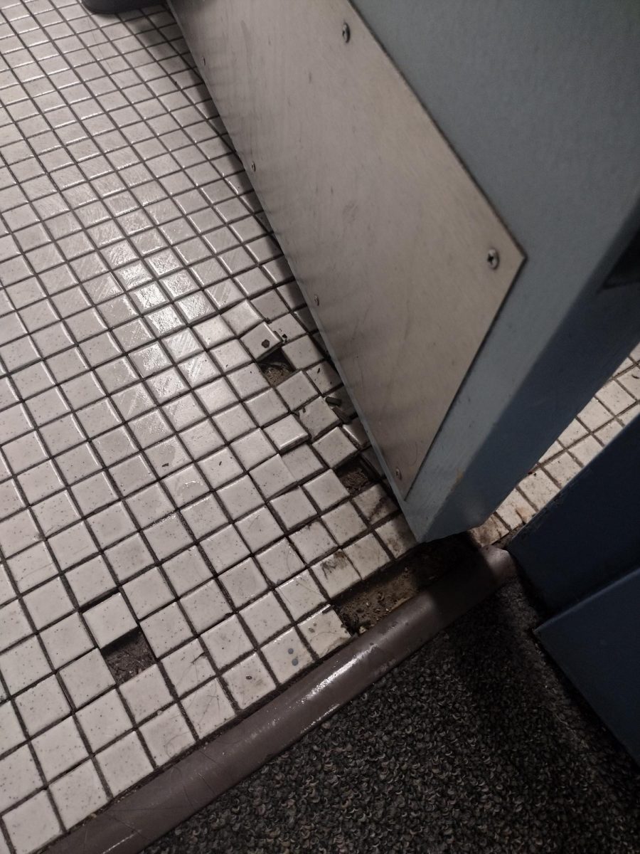 Cracked tiles rest on the floor of a bathroom in the Tolman Residence Hall.